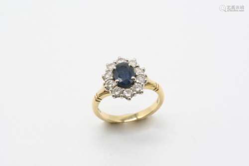 A SAPPHIRE AND DIAMOND CLUSTER RING the oval-shaped sapphire is set within a surround of ten