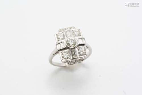 A DIAMOND CLUSTER RING the circular-cut diamond is set within a surround of baguette-cut and