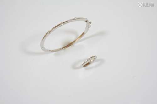 AN 18CT. WHITE GOLD AND DIAMOND BANGLE the half hinged bangle is mounted to one side with three