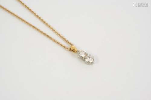 A DIAMOND TWO STONE PENDANT mounted with two brilliant-cut diamonds, in gold, on a fine link gold
