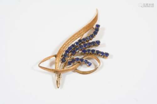 A SAPPHIRE AND GOLD FOLIATE SPRAY BROOCH mounted with circular-cut sapphires and gold leaves, in
