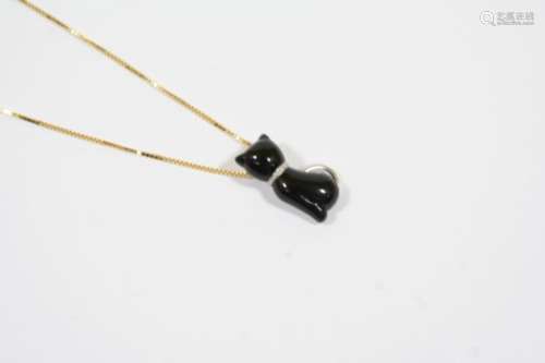 A BLACK ONYX CAT PENDANT mounted in 18ct. white gold and on an 18ct. yellow gold fine link chain,