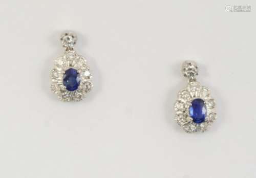 A PAIR OF SAPPHIRE AND DIAMOND DROP EARRINGS each earring set with an oval-shaped sapphire within