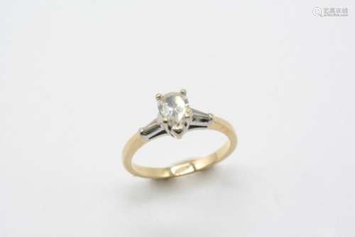 A DIAMOND SOLITAIRE RING the pear-shaped diamond is set with a tapered baguette-cut diamond to