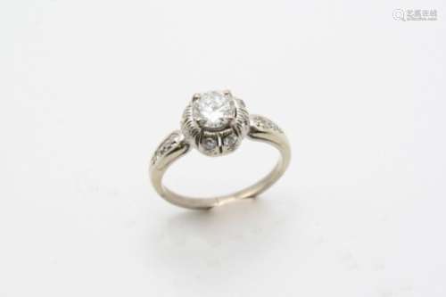 A DIAMOND CLUSTER RING the round brilliant-cut diamond weighs 0.76 carats and is set within a