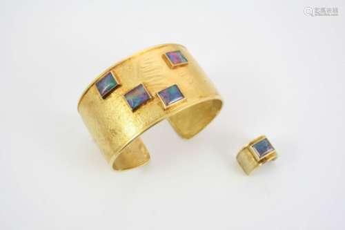 A BLACK OPAL AND GOLD BANGLE BY GERALD BENNEY the 18ct. gold bangle is textured to look like suede