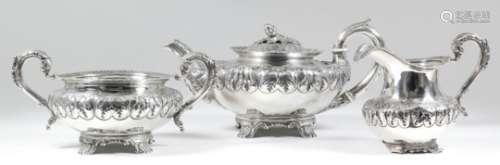 A George IV silver three-piece tea service, the squat circular bodies boldly embossed with flower