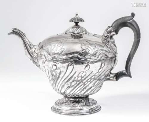 An early George III silver circular teapot of slight baluster shape, the part spiral reeded and