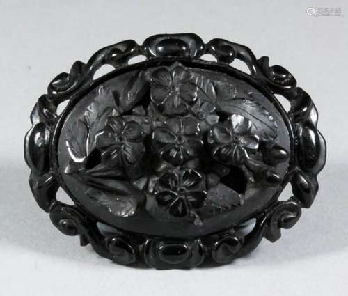 A black composition mounted oval brooch, inset with 