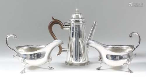 A pair of Edward VII silver oval sauce boats with shaped rims and leaf capped double C-scroll