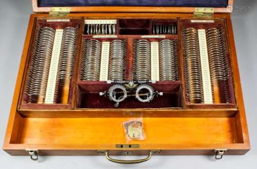 A set of early 20th Century ophthalmic testing lenses, and folding optical glasses, in fitted