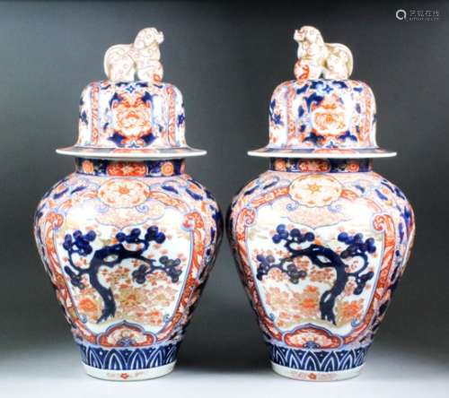 A pair of Japanese Imari porcelain baluster vases and covers with dog of Fo finials, decorated in