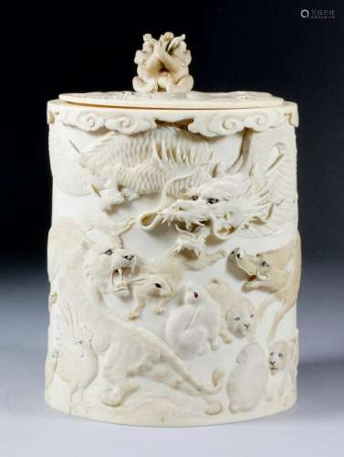 A Japanese ivory tusk pattern box and cover, the body carved in bold relief with a tiger, dragon,