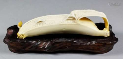 A fine Japanese carved ivory and yellow stained okimono in the form of a partly peeled banana, the
