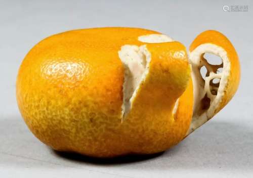 A fine Japanese carved ivory and orange stained okimono in the form of a partly peeled tangerine,