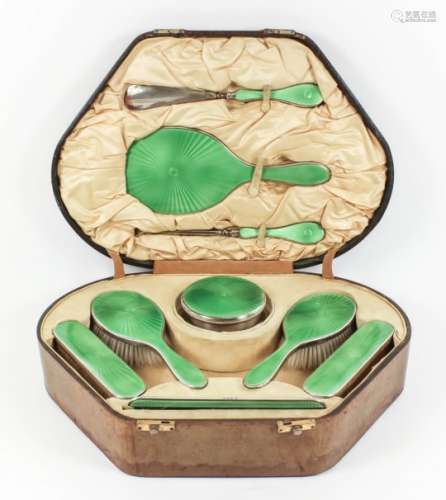A George V lady's silver and green enamel backed nine-piece dressing table set with emerald green