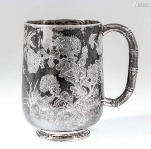 A Chinese silvery metal tankard engraved with bamboo shoots, flowering branches and insects, with