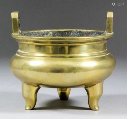 A Chinese bronze two-handled circular censer of squat form on three plain feet, 4.375ins (11.1cm)