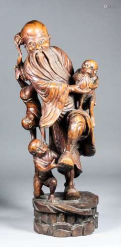 A 19th Century Japanese root carving of a bearded man with three cheeky monkeys, 28ins (71.1cm)