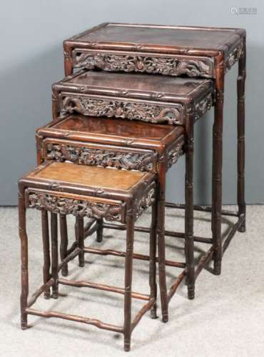 A nest of four Chinese hardwood rectangular occasional tables with panelled tops, the aprons fretted
