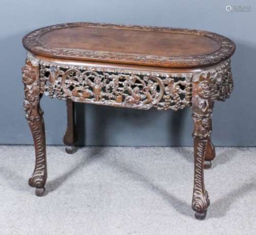 A Chinese hardwood rectangular centre table with bowed ends, the panelled top with border carved