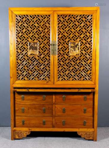 A Chinese elm cabinet, the upper part fitted six shelves enclosed by a pair of carved and fretted