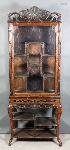 A Chinese hardwood display cabinet, the whole carved with bamboo shoots, the shaped cresting fretted