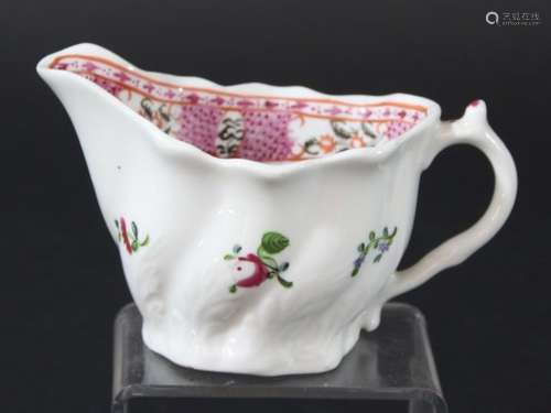 LOWESTOFT LOW CHELSEA EWER CREAM JUG, circa 1770, painted with a band of floral panels on a pink