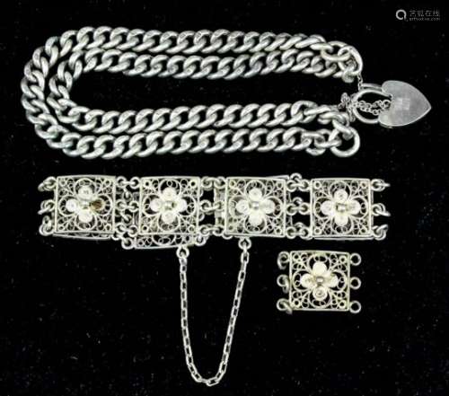 A silver double chain link bracelet with hear pattern padlock clasp, a silver filigree bracelet