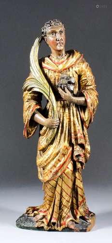 A Continental carved wood figure of St. Stephen holding in his right hand a palm leaf symbolising