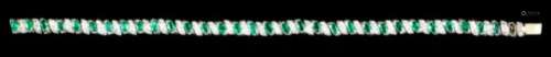 A modern white coloured metal, emerald and diamond bracelet, set with thirty-one oval cut