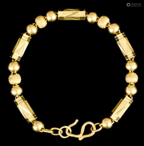 A gold coloured metal bracelet, set with five hexagonal links interspersed by three ball pattern