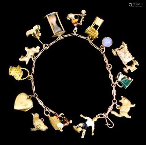 A 9ct gold link bracelet hung with twelve various charms, and with two other loose charms (gross