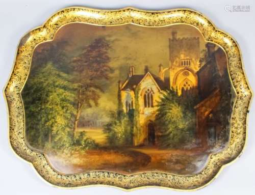 A Victorian papier mache tray of shaped outline, the centre painted with a view of Buckland Abbey,