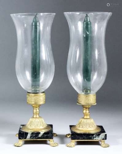 A pair of Continental gilt brass and polished marble storm candlesticks, on lion paw feet, and