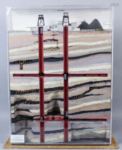 A sectional cased model of a working coal mine showing pit head and associated buildings, with