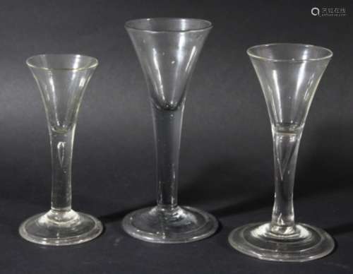 GROUP OF THREE WINE GLASSES, circa 1770, the drawn trumpet bowls above plain stems, two with