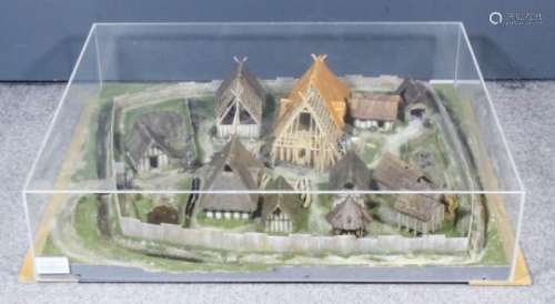 A cased painted, wood and composition model of an Anglo-Saxon village within palisade and ditch,