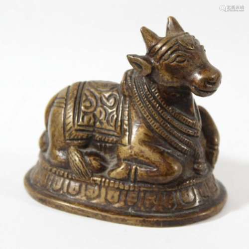 INDIAN BRONZE FIGURE OF SHIVAS NANDI BULL, recumbent with a patterned cover, length 7.5cm
