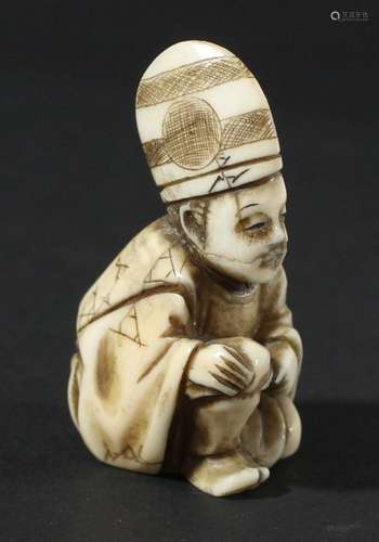 JAPANESE NETSUKE, Meiji, carved as a priest kneeling down wearing a tall hat, height 4.5cm