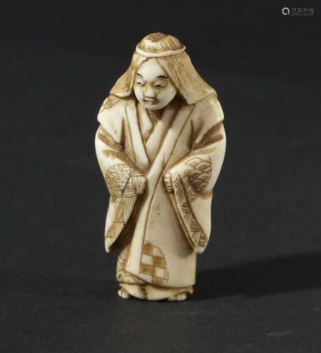 JAPANESE IVORY NETSUKE, Meiji, carved as a figure standing in a full length robe, signed, height