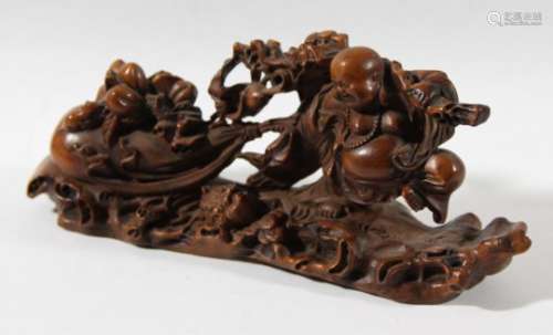 CHINESE BOXWOOD CARVING, 19th century, of Buddha pulling a large sack surrounded by fruiting
