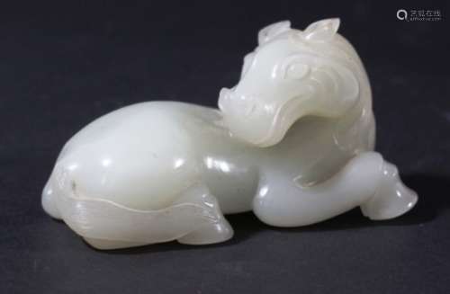CHINESE WHITE OR PALE CELADON JADE HORSE, recumbent, looking over its back, length 8cm