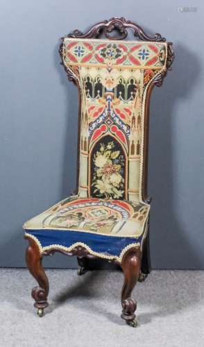 A Victorian rosewood framed Prie-Dieu with scroll carved cresting, the seat and back upholstered