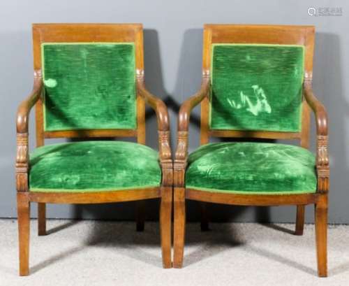 A pair of 19th Century French Empire mahogany armchairs with plain crest rails and dolphin scale