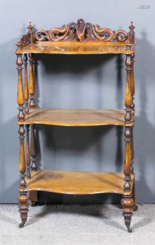 A Victorian walnut serpentine fronted rectangular three-tier whatnot, with fretted gallery to the