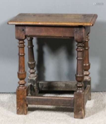 A 17th Century oak joint stool with moulded edge to top, on turned legs with block toes and plain