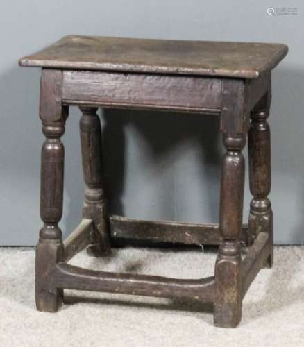 A 17th Century oak joint stool with moulded edge to top, on plain turned legs with block toes and