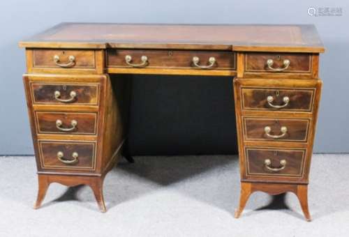 An early 20th Century mahogany kneehole desk with recessed front, the whole inlaid with