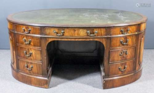 A mahogany oval kneehole partners desk of 
